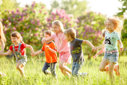 A group of happy children of boys and girls run in the Park on t